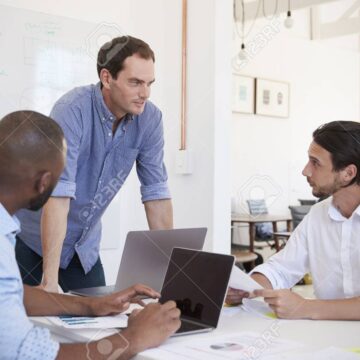 Three young men discussing business at an office meeting