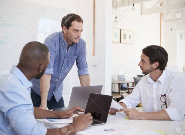 Three young men discussing business at an office meeting