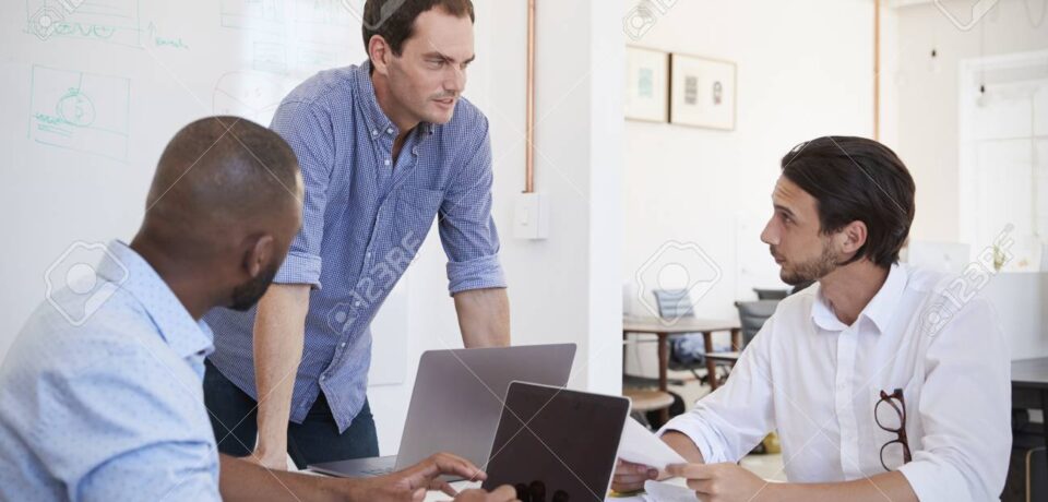 Three young men discussing business at an office meeting