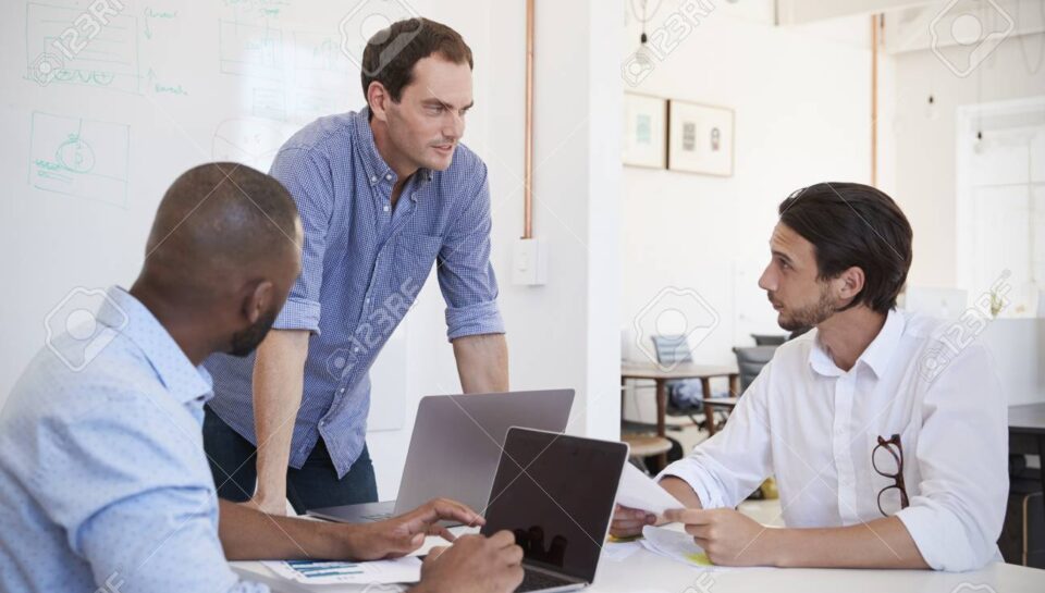 Three young men discussing business at an office meeting Three young men discussing business at an office meeting